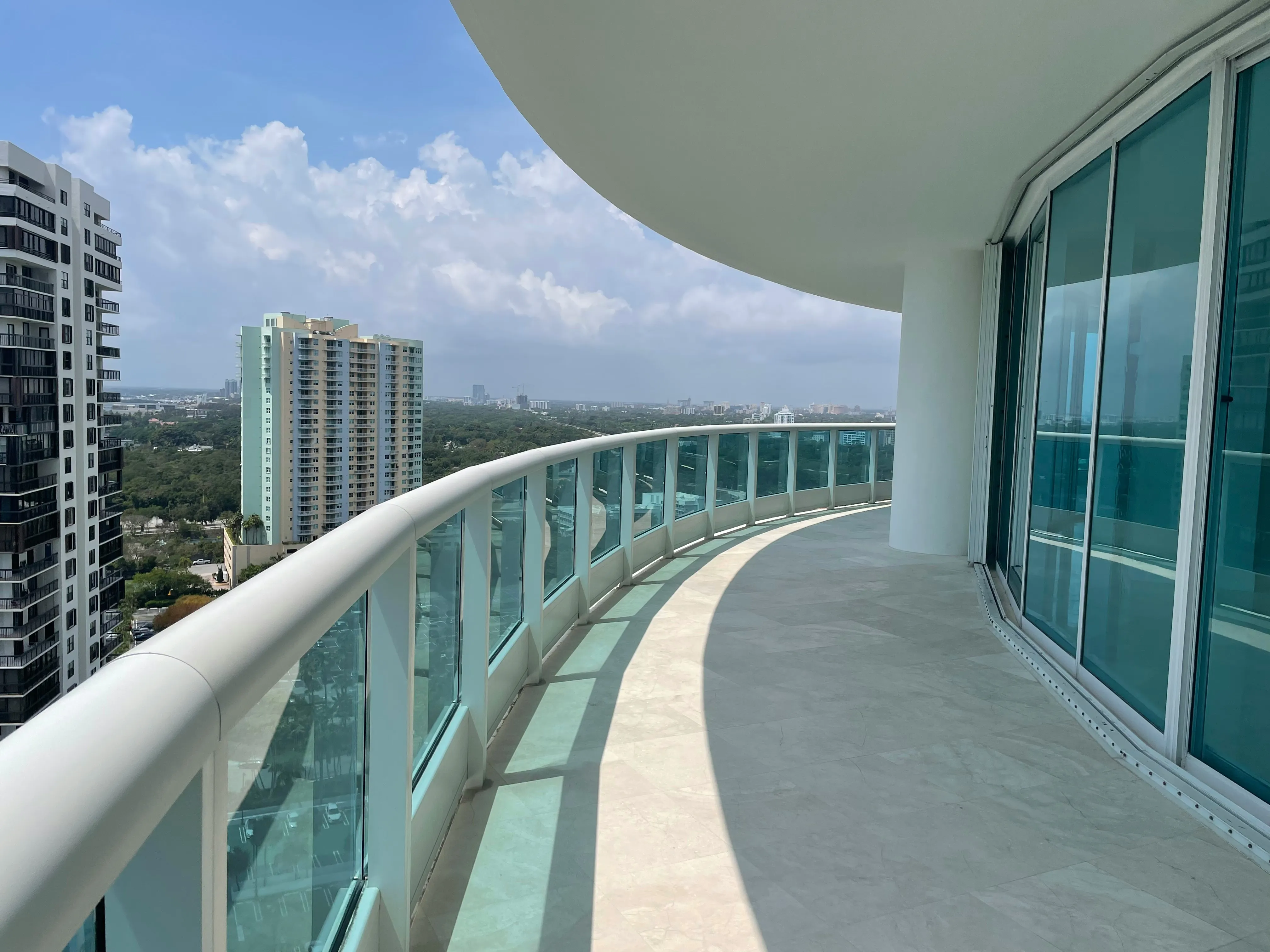 Curved wraparound balcony with city and sky views